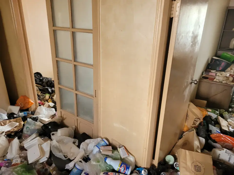 문 앞까지 물건이 쌓여 있는 방 내부