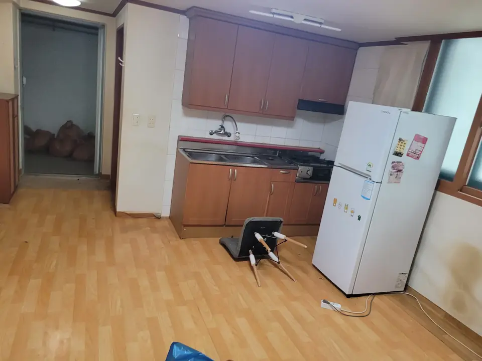 냉장고와 주방이 보이는 비워지는 중인 방