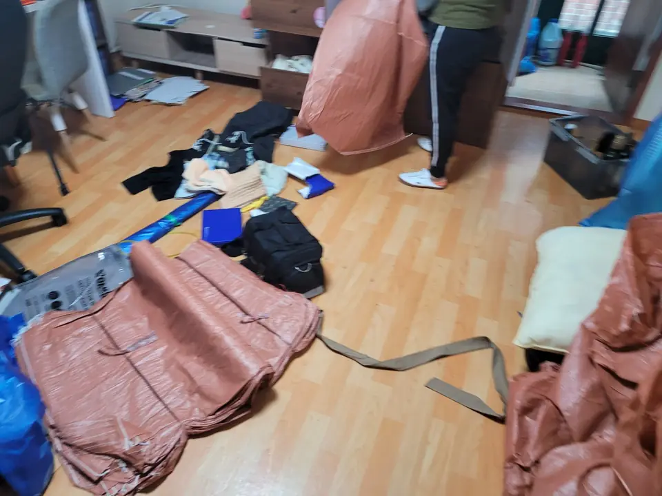 방 바닥에 마대를 펼쳐 놓고 물품을 모으는 모습