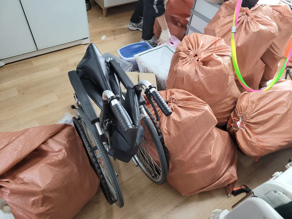 휠체어와 마대가 놓인 방 내부